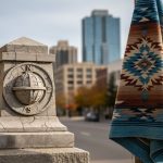 Autumn street scene featuring symbolic monument and woven fabric representing Columbus Day and Indigenous Peoples Day, with no readable text.
